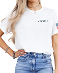 front image of white tshirt with a 1776 and two stars along with a betsy ross flag on the arm