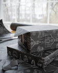 Wedding presents with black and white pattern on a table with scissors and additional wrapping paper.