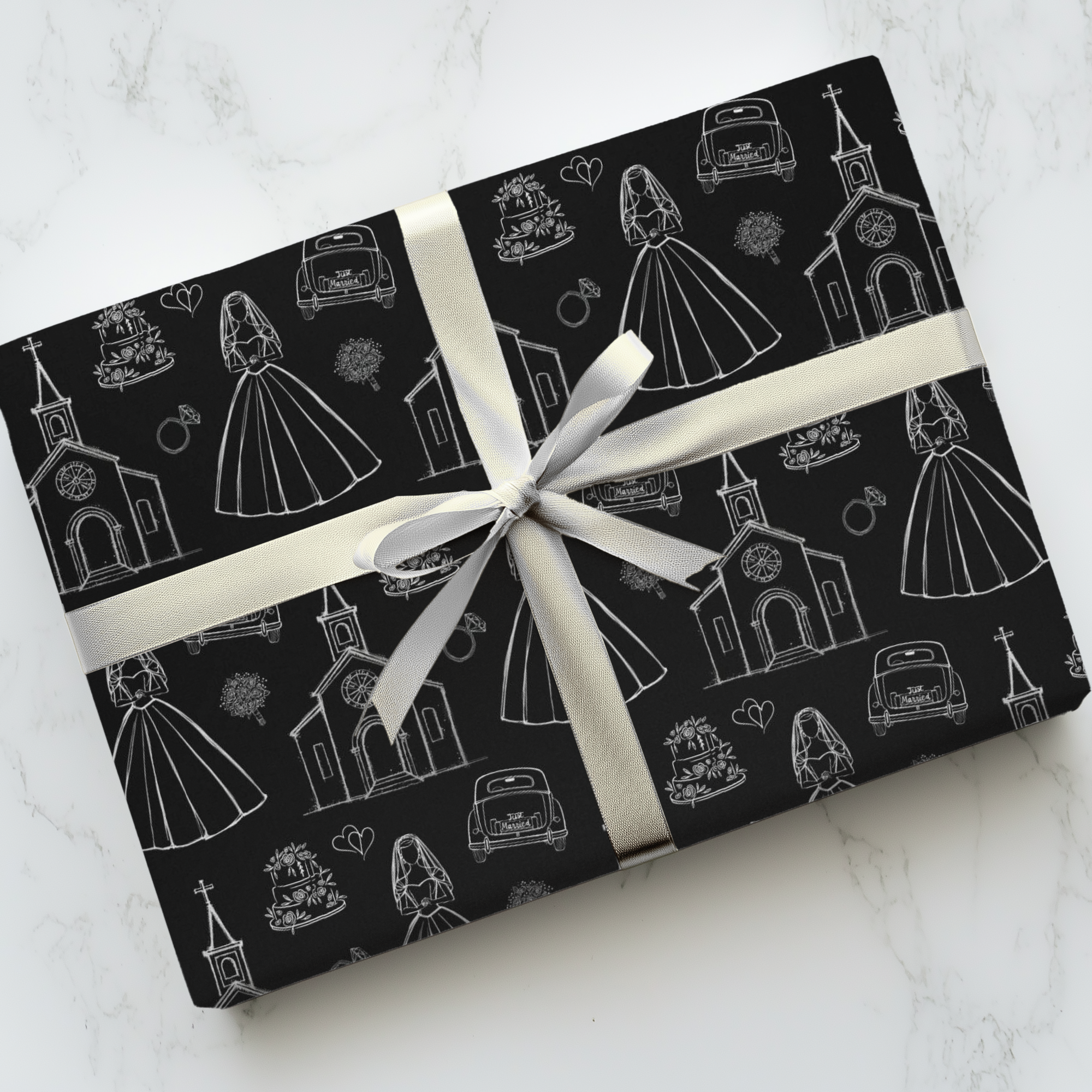 Wedding gift wrapped in black patterned paper with a white ribbon on a light gray background.