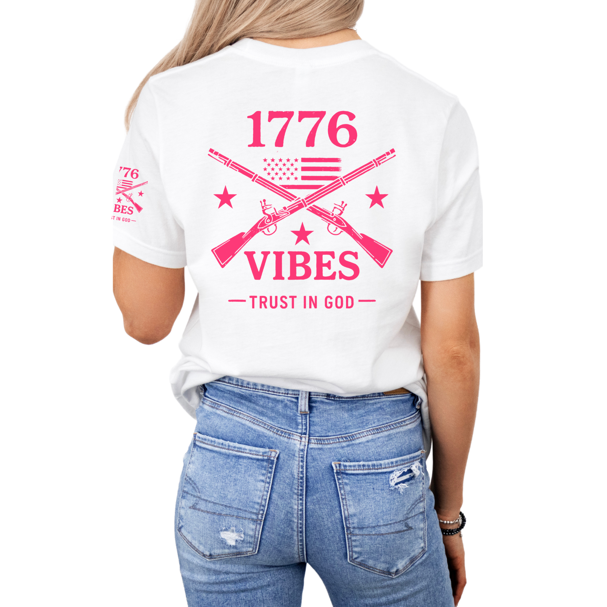Woman wearing a white t-shirt with pink text that says 1776 vibes trust in God with muskets and an american flag   on the back